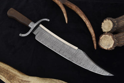 Damascus steel Texas Bowie knife displayed with a wooden leather-wrapped scabbard, emphasizing its craftsmanship and historical design. A luxury handmade blade for display or practical outdoor use.