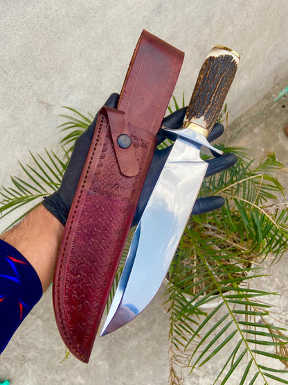 Close-up of handmade Bowie knife handle crafted from natural material with detailed brass guard and polished finish.