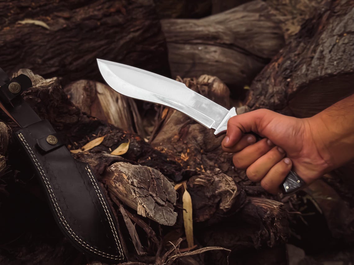 Full view of the hand-stitched leather sheath with brass hardware and reinforced stitching.