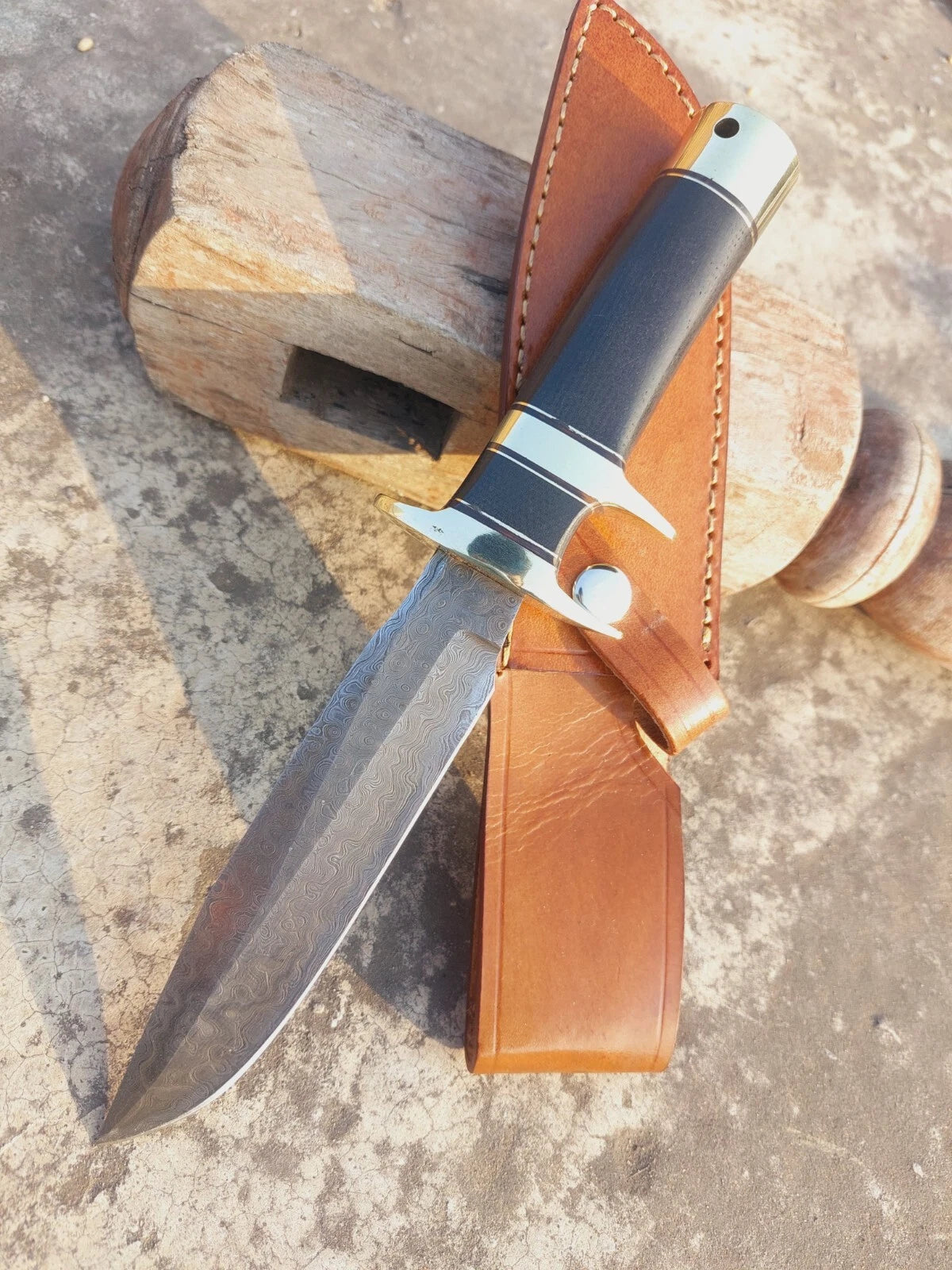 Damascus blade hunting knife with micarta handle grip and brass accents, crafted for both beauty and strength. This handmade knife includes a stitched leather sheath, ideal for hunters, campers, and outdoor enthusiasts.