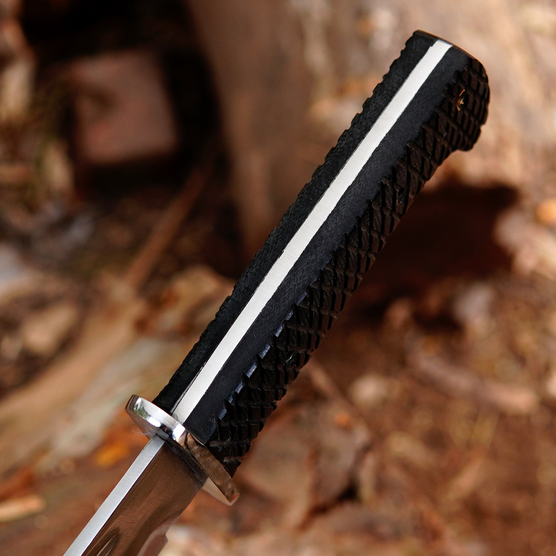 Detailed image showing black textured handle of handmade bowie knife designed for secure grip and comfortable handling during outdoor use highlighting craftsmanship and ergonomic shape suitable for extended use in camping and outdoor environments.