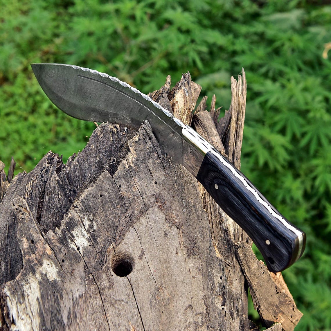 Custom handmade Damascus knife with curved Kukri blade, brown leather sheath, and high-carbon steel layers, perfect for collectors and adventurers.