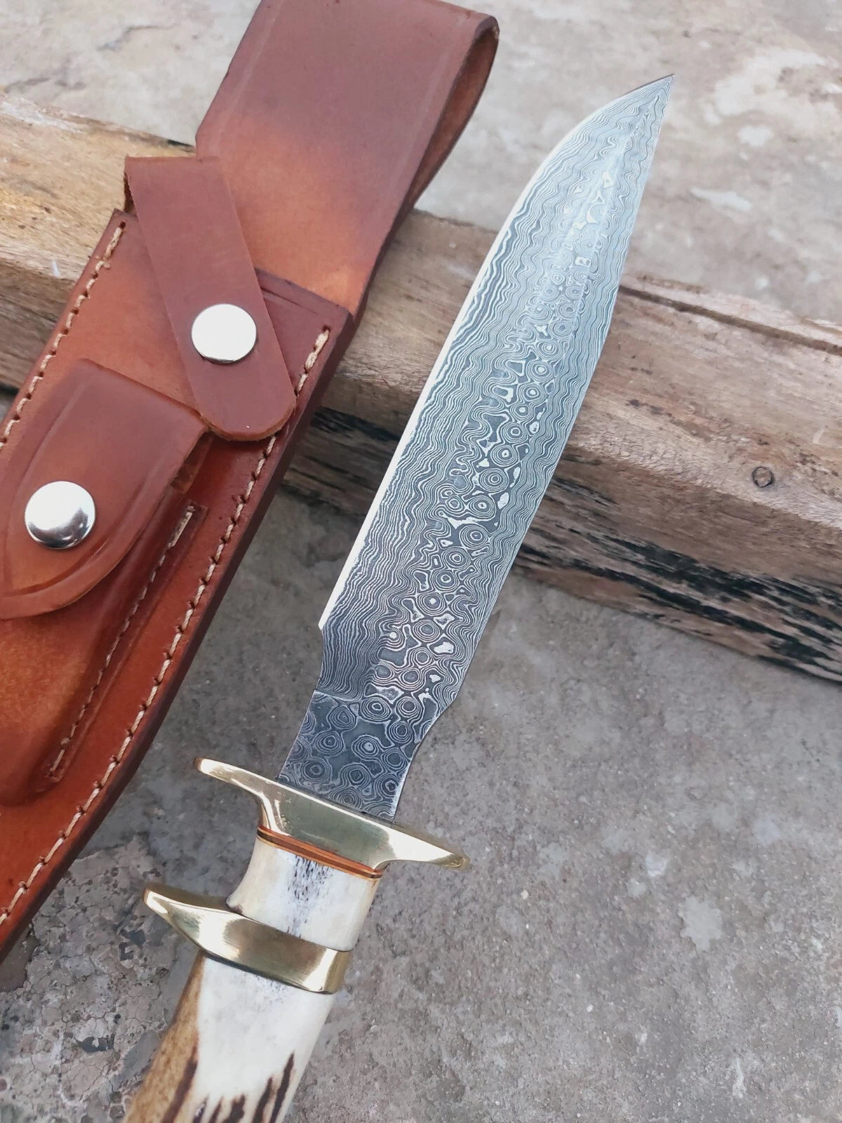 Collector Damascus knife with stag handle, subhilt design, and layered steel blade. The knife blends functionality with elegance, supplied with a stitched sheath for safe carry and long-term use.