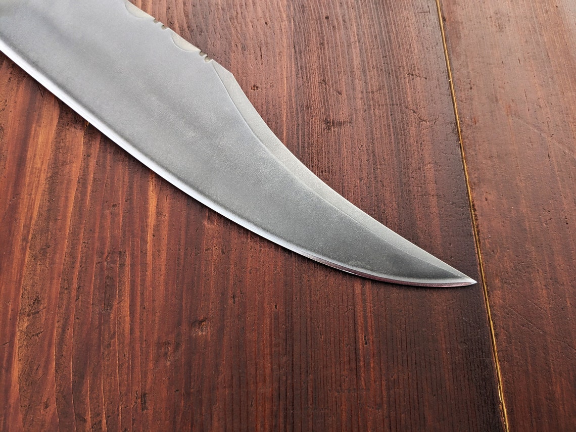 Classic handmade carbon steel Bowie knife featuring polished camel bone handle and satin finish, perfect for collectors or outdoor adventurers looking for strength and design balance.