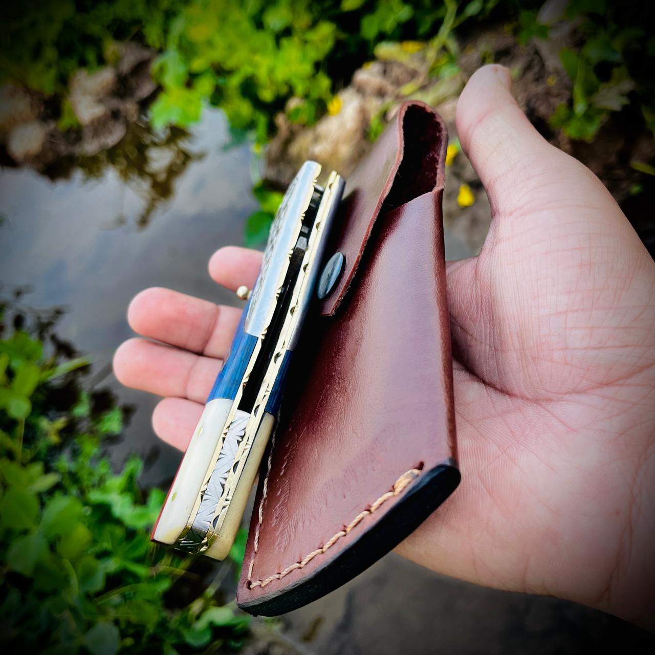 Damascus folding pocket knife closed position showing patriotic handle style and compact carry design.