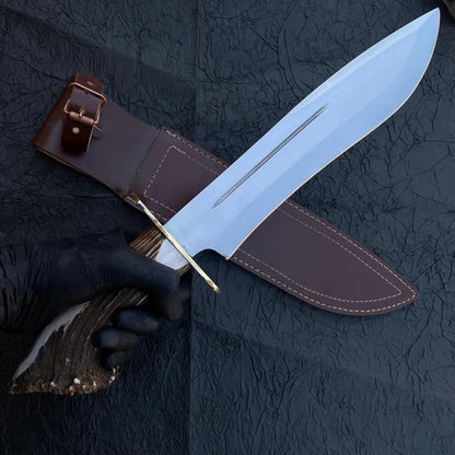 Close-up of custom Bowie knife showing detailed brass guard, handmade carbon steel blade, and antler crown handle.