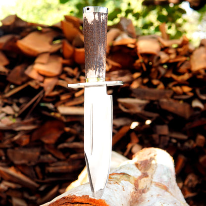 Close-up of a polished steel blade bowie knife with solid guard and refined finish.
