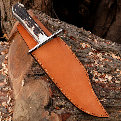 Handmade outdoor knife placed on wood with a premium leather sheath for safe carry.