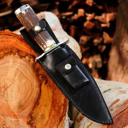 Custom crafted bowie knife featuring a clean polished blade and textured natural material handle.