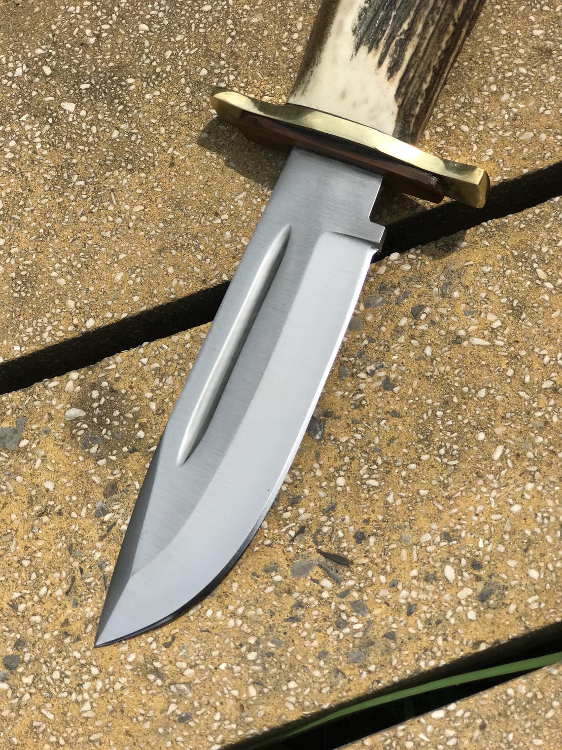 Brass guard and stag handle close-up of a handmade carbon steel Bowie knife showing its craftsmanship, natural texture, and detailed finish. A premium collector’s piece for hunters and adventurers, perfect for display, survival use, or gifting.