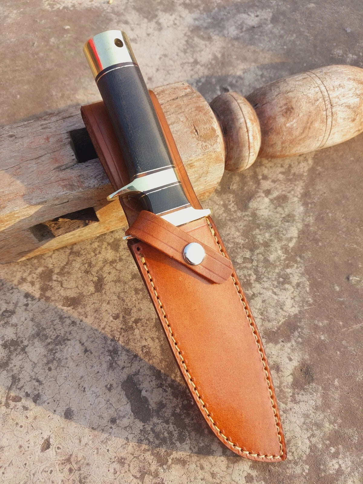 Handmade Damascus steel hunting knife with micarta handle, subhilt guard, and brass fittings. The detailed blade patterns make each knife unique, while the leather sheath provides safe carrying. Designed for outdoor use and collection.