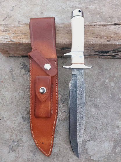 Forged Damascus hunting knife with bone handle and subhilt guard. Includes leather sheath for secure carry. Strong outdoor knife with layered steel beauty, perfect for hunting and survival use.
