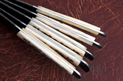 A kitchen knife set of 5 handmade Damascus steel blades with white natural material handles. Built with full tang durability, this chef set comes with a leather kit for storage. Engraving is free, making it a thoughtful gift.