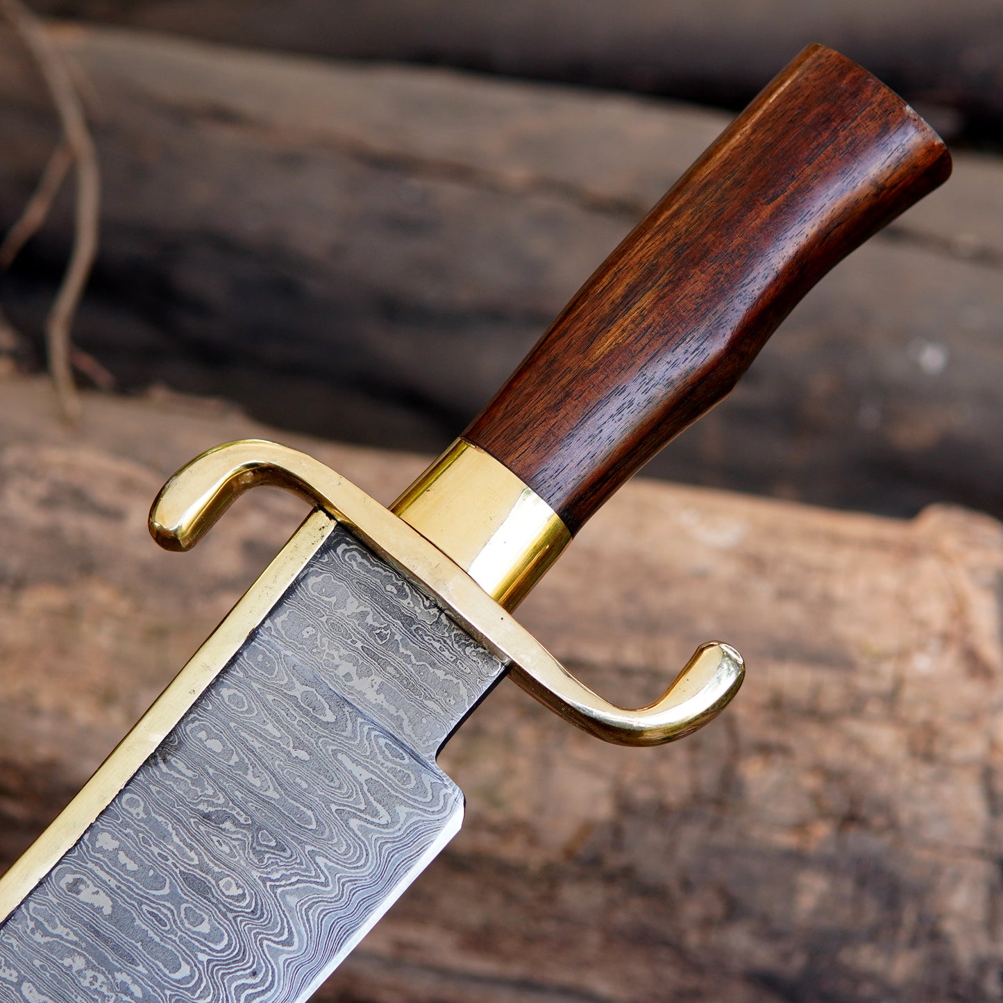 Wooden handle closeup of handmade bowie knife showing smooth polish, ergonomic shape, and brass guard connection. The image focuses on grip comfort and traditional styling, suitable for buyers looking for strong and visually appealing handmade outdoor knives.