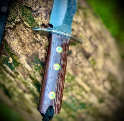 Close-up of wooden handle with three brass pins and lanyard hole showing fine polishing and fit.